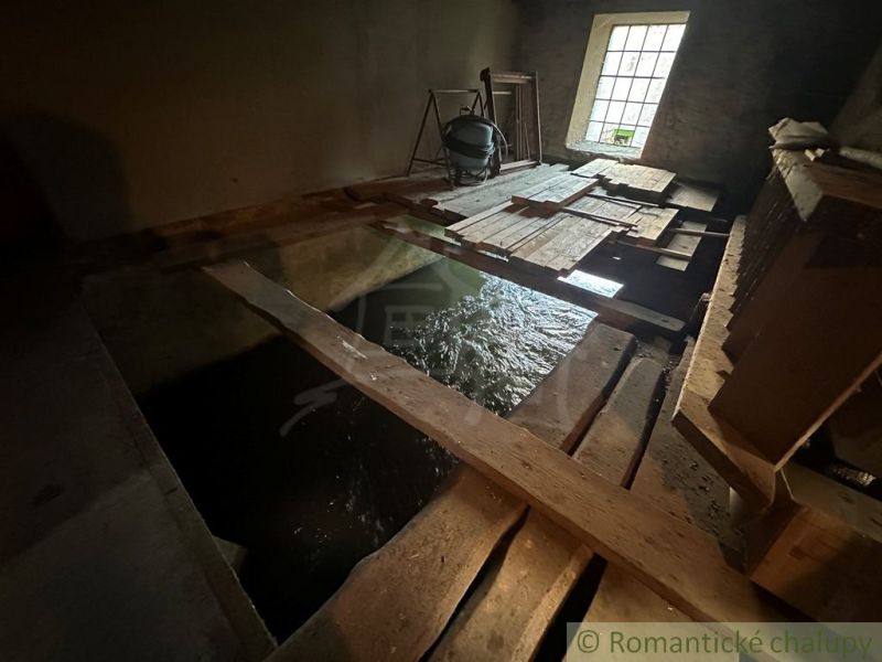 Interior of a family house with flowing water and wooden boards on the floor.
