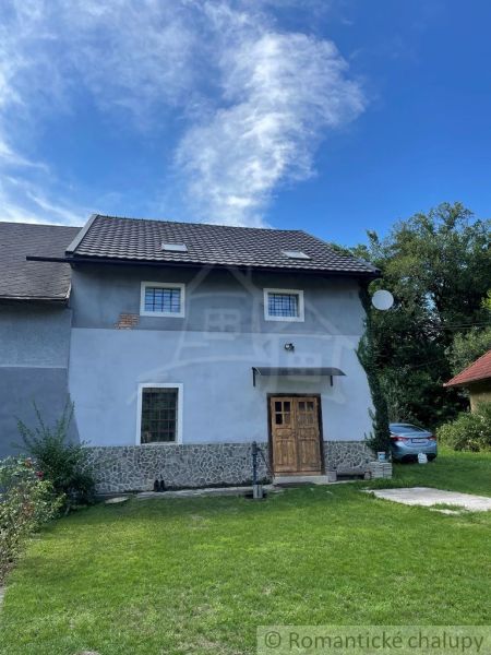 A family house in Mokrá Lúka with a stone facade and wooden doors.