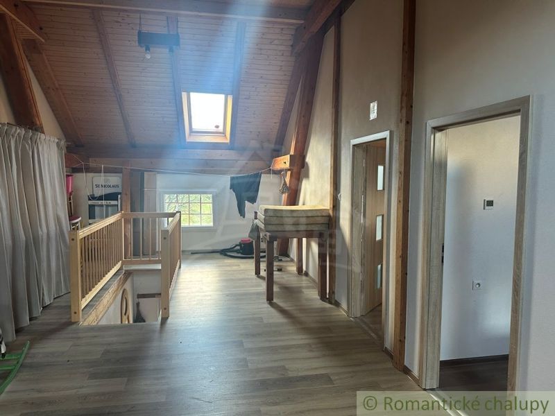 Attic in a family house with wooden beams and a wooden decor floor.