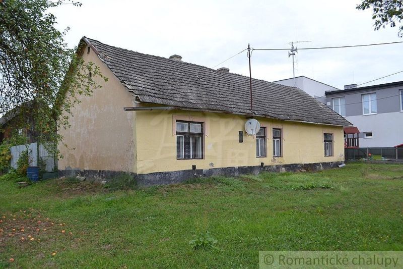 Yellow family house in Nemcovce with a grassy plot and a satellite dish.