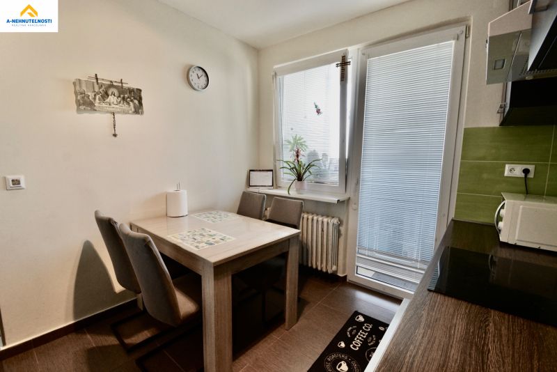 Kitchen in a 3-room apartment with a dining table and chairs, light decoration.