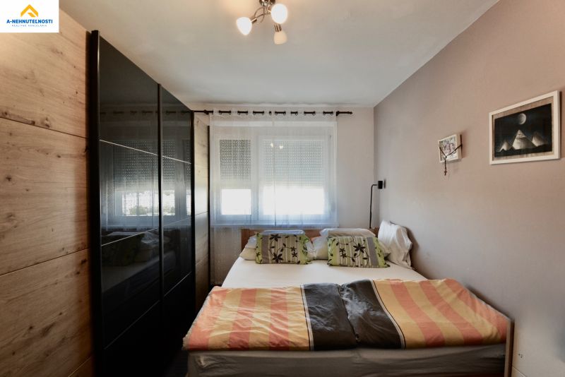 Bedroom with a bed, built-in wardrobe, and a window in a 3-room apartment.