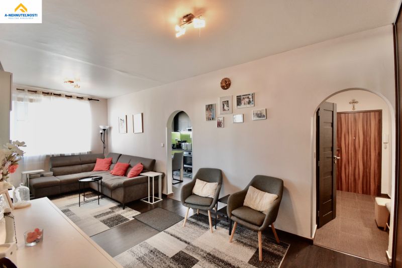 Living room in a 3-room apartment with a wooden decor floor and a comfortable sofa set.