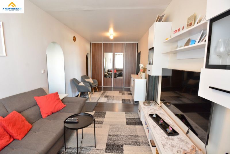 Living room in a 3-room apartment with a comfortable sofa, armchairs, and storage space.