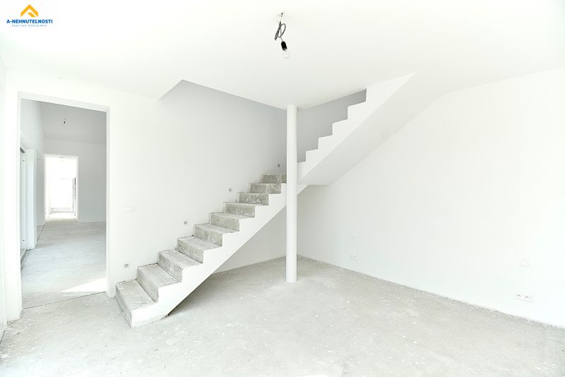A bright room with unpainted concrete stairs and white walls in a family house.