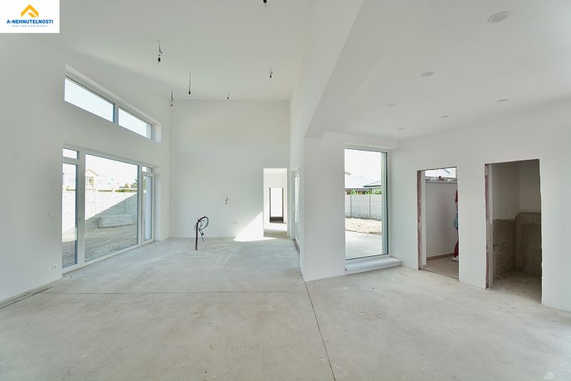 The interior of a family house with large windows and light walls.