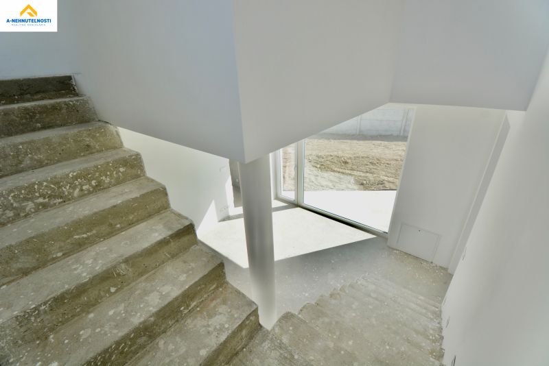 Concrete staircase and light walls in the interior of a family house.
