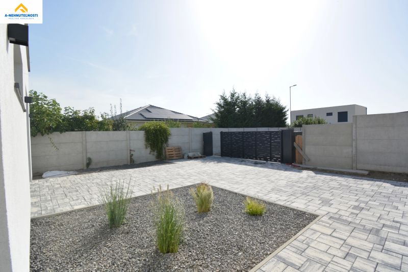 The courtyard of a family house on Kráľovianky in Šamorín with paving and greenery.