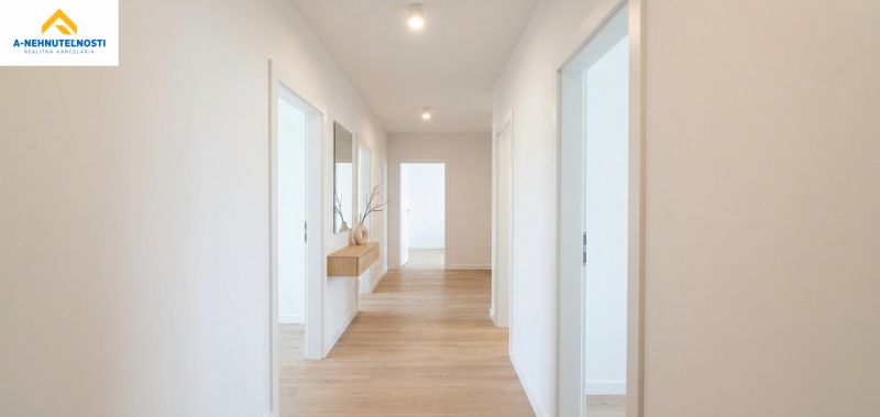 A hallway in a 3-room apartment with a wooden decor floor and decorations on the wall.