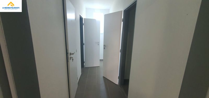 A hallway with multiple doors and tiles in a 3-room apartment.