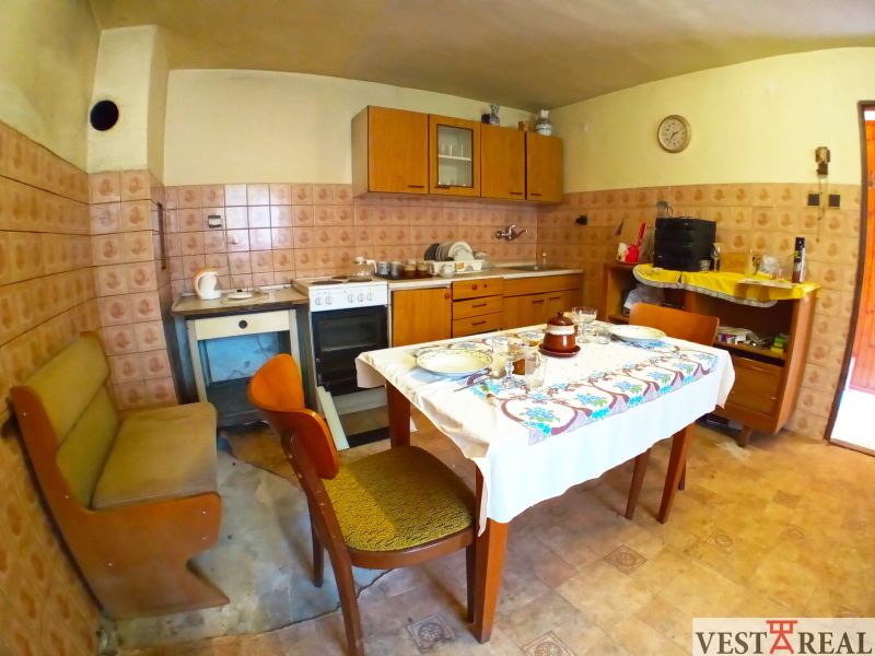 A kitchen in a family house with classic furniture and patterned tiles.