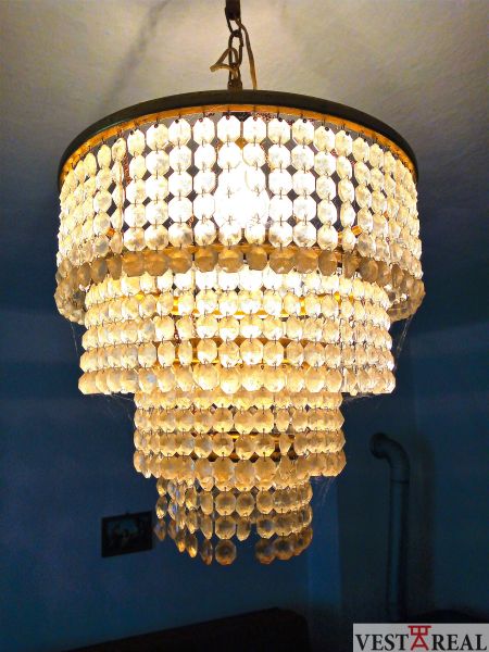 A crystal chandelier in the interior of a family house with soft lighting.
