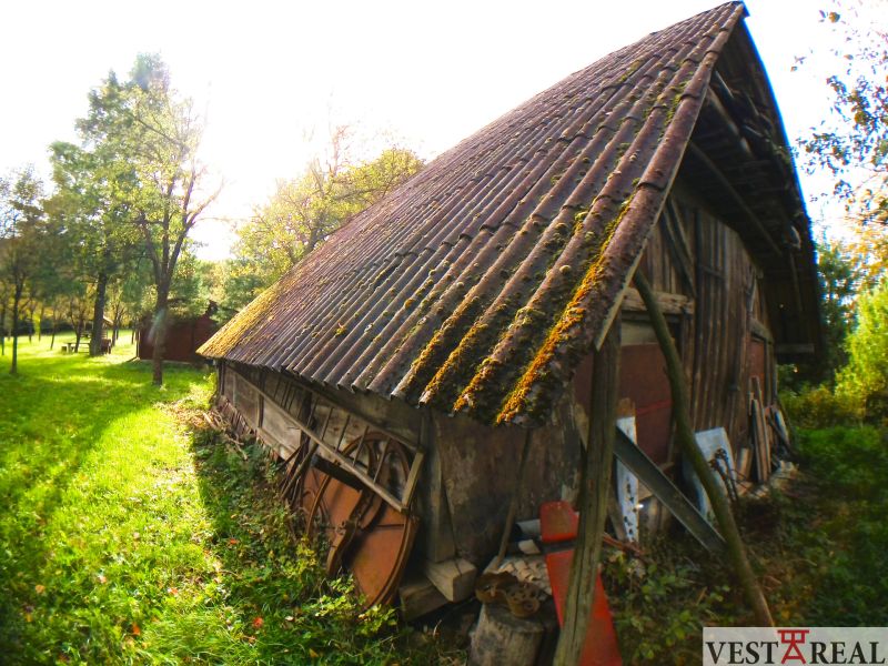 An older wooden building with a metal roof in the garden of a family house in Buková.