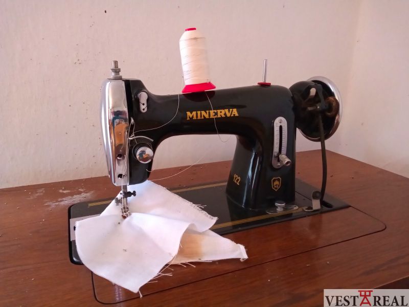 A Minerva sewing machine on a wooden table in a family house.