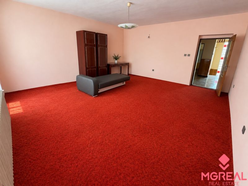 Living room with a red carpet and a cabinet in a family house.