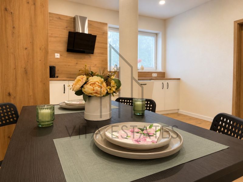 A kitchen in a 3-room apartment with a wooden decor floor and a dining table.