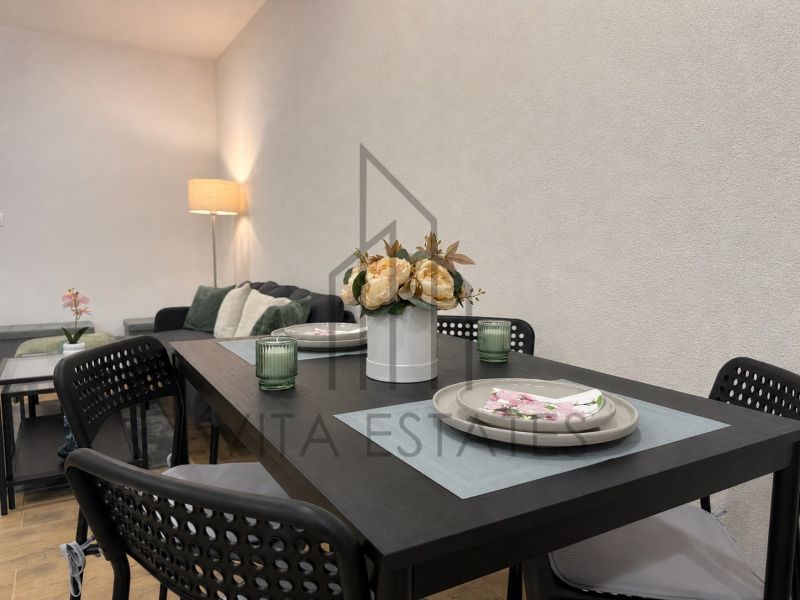 Dining area with floral decoration in a 3-room apartment, table and chairs.