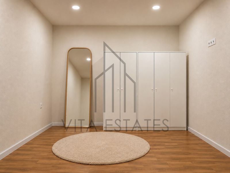 A beige room with wood-patterned flooring, a mirror, and built-in wardrobes in a 3-room apartment.