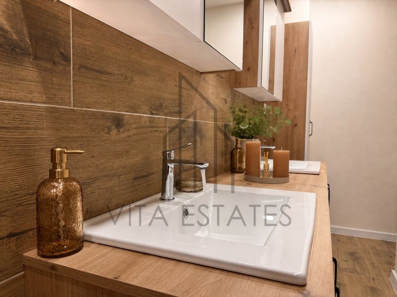 A bathroom in a 3-room apartment with wooden decor furniture and candles.