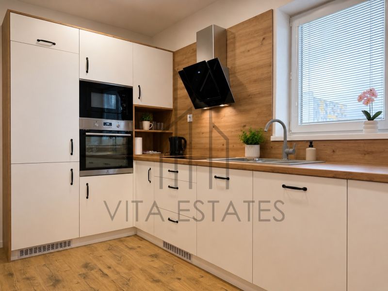 A kitchen with white cabinets and a wood-patterned floor in a 3-room apartment.