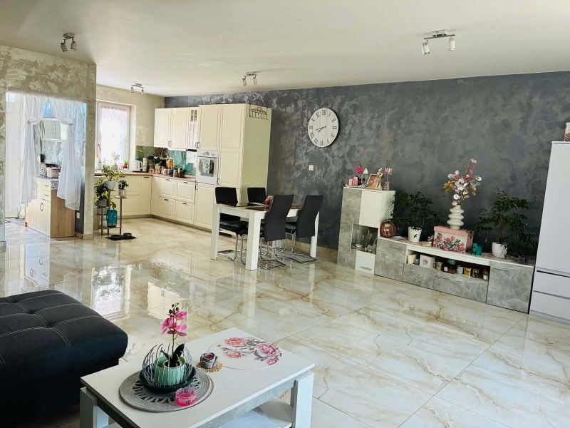Interior of a family house with a white kitchen, dining table, and decorative elements.