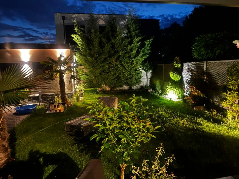 The night garden of the family house on Agátová Street in Kostolište with lighting and greenery.