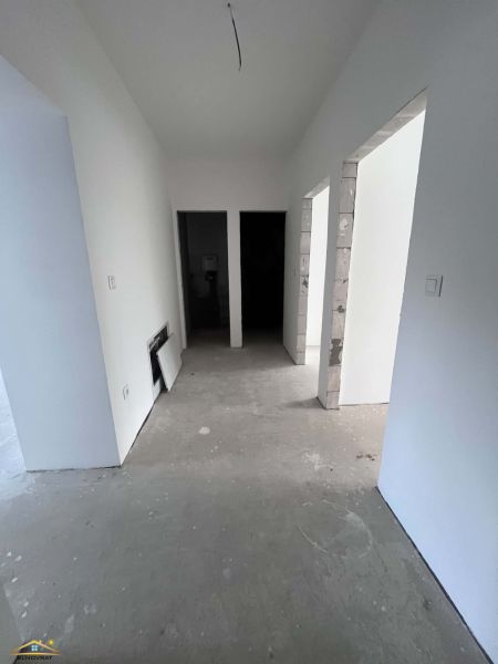 A hallway in a 3-room apartment with thick concrete floors and white walls.