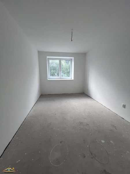 An unfurnished room in a 3-room apartment with white walls and a window.