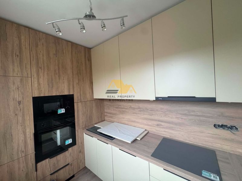 Kitchen in a 2-room apartment with storage cabinets and a built-in oven.