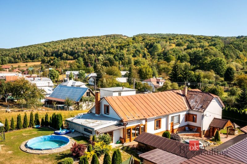 A family house in Potoky surrounded by a garden with a swimming pool and hilly nature.