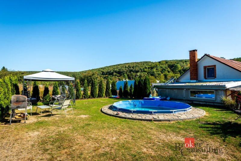 A family house in Potoky with a swimming pool and a gazebo amidst greenery.
