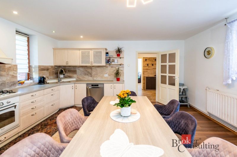A kitchen in a family house with wooden decor and floral decoration on the table.