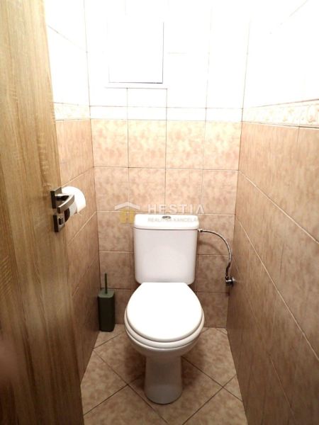 A bathroom in a 3-room apartment with ceramic tiles and subdued lighting.