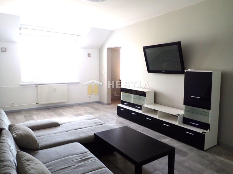 Living room with a sofa, TV, and wooden decor flooring in a 3-room apartment.