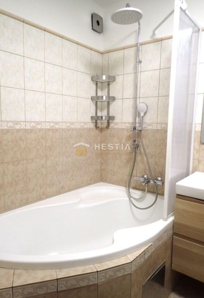A bathroom with a shower and a bathtub in a 3-room apartment.