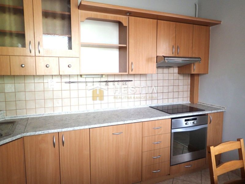 A kitchen in a 3-room apartment with a wooden decor and built-in appliances.