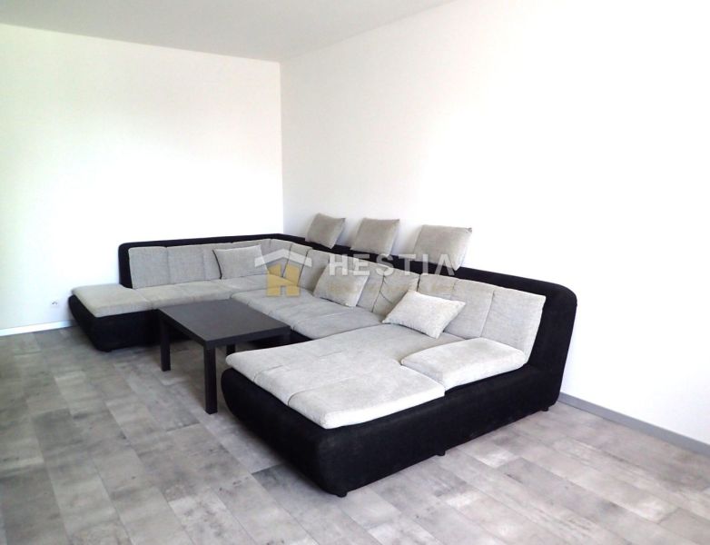 A large corner sofa in a 3-room apartment with a wooden decor floor.
