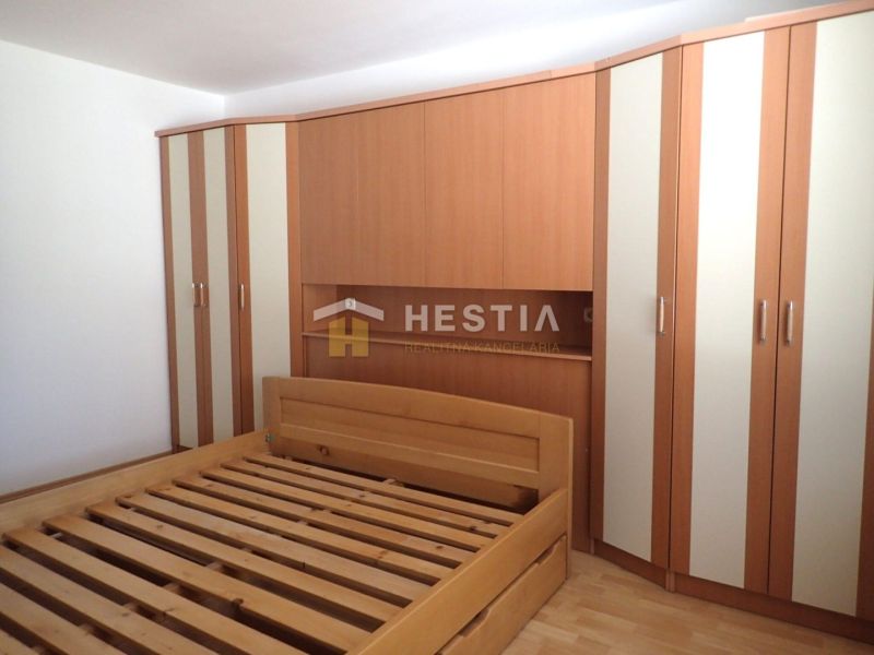 Bedroom in a 3-room apartment with a bed and a built-in wardrobe, floor with wood decor.