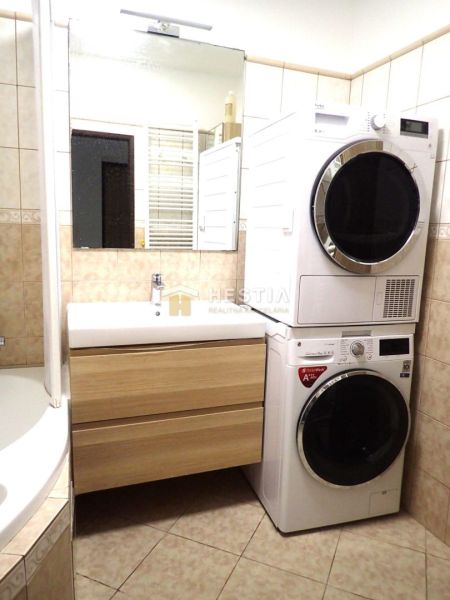 Bathroom with a washing machine and dryer, sink, and bathtub in a 3-room apartment.