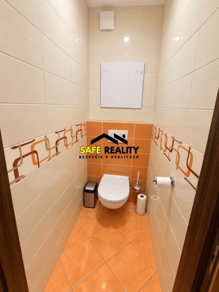 A bathroom in a 3-room apartment with orange tiles and a toilet.