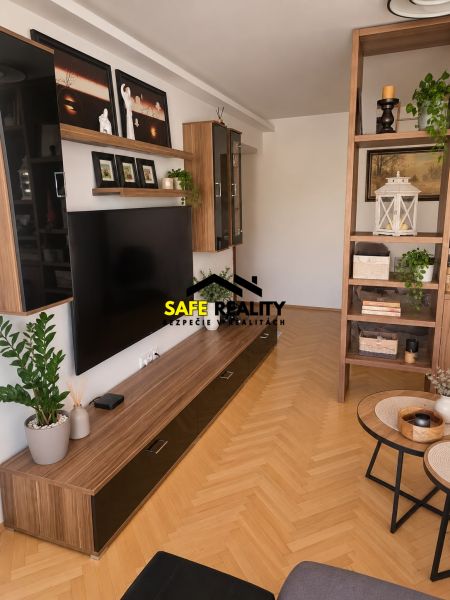 Living room in a 3-room apartment with a wooden decor floor and a wall shelf.