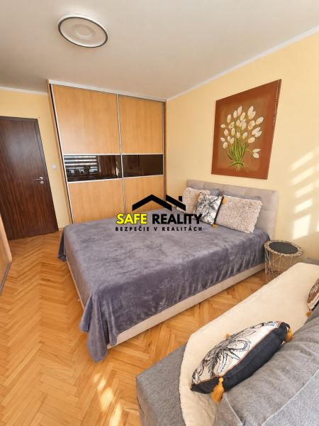 A bedroom in a 3-room apartment with a spacious wardrobe and a floor with a wooden decor.