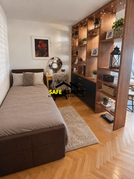 A bedroom in a 3-room apartment with a wood-decor floor and cozy furnishings.