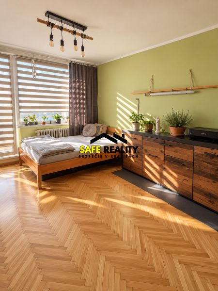 A bedroom in a 3-room apartment with a wooden decor floor and plants.