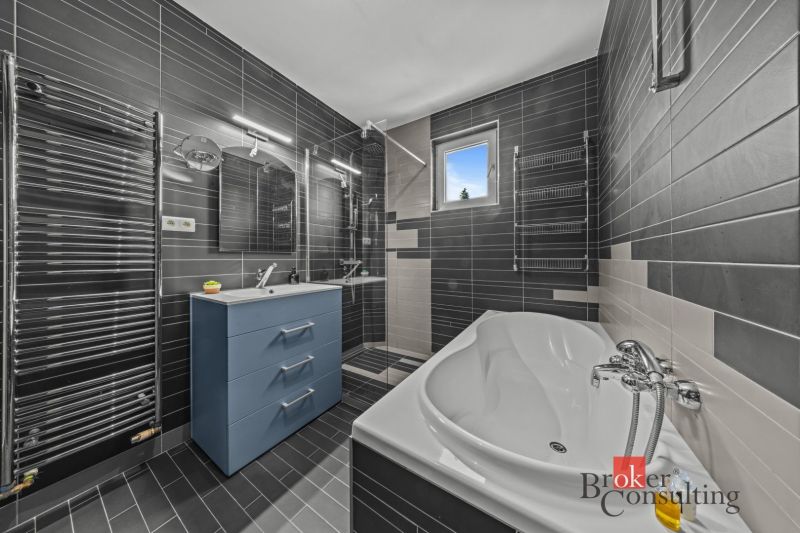 A bathroom in a villa with a bathtub, shower, and blue sink.