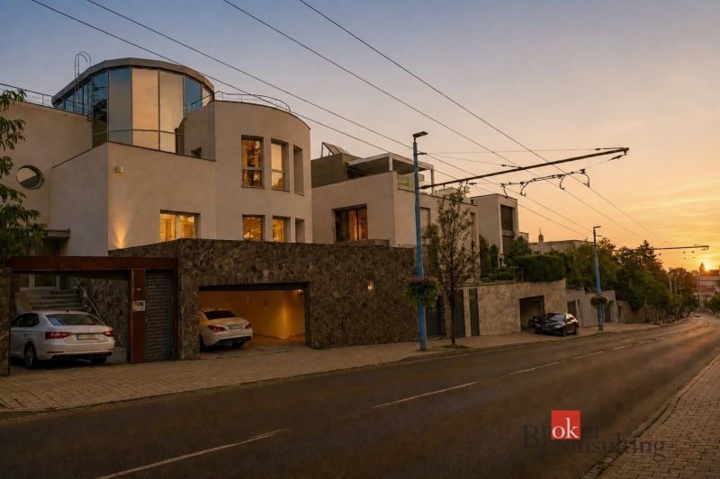 A villa in Bratislava-Old Town illuminated at night, surrounded by a stone fence.