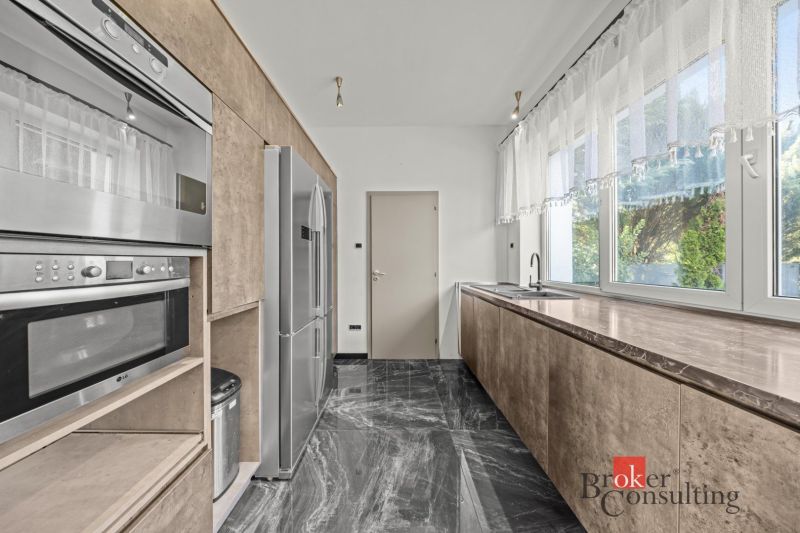 A modern kitchen with a marble floor and built-in appliances in a villa.