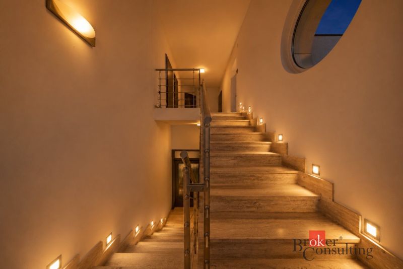 The interior of the villa with a stone staircase and subtle lighting on the walls.