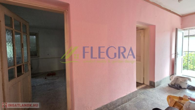 A pink wall and open doors in a family house with access to the terrace.