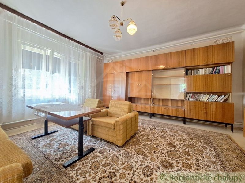 Living room in a family house with retro furniture and a large glass wall.